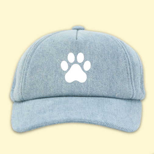 Two light blue caps with paw print designs on a beige background